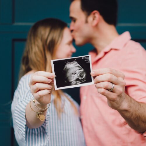 Couple showing their baby scans